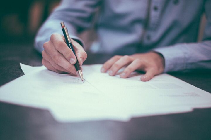 An adviser and a client signing an account-opening form